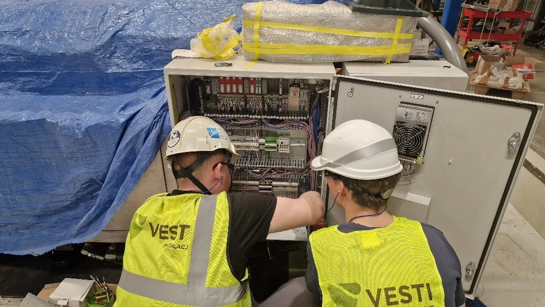 VESTI technicians working on an industrial control cabinet